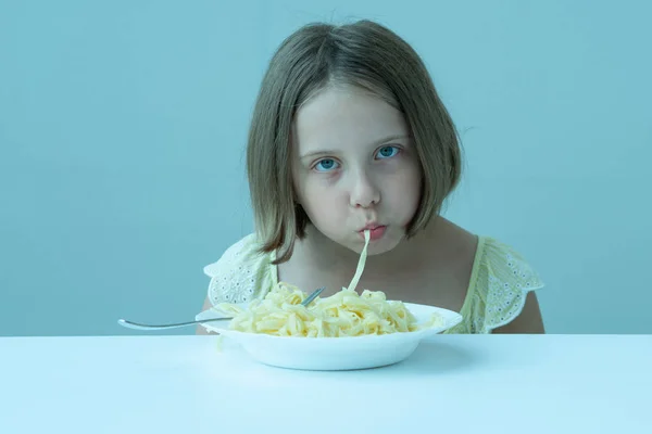 Menina Comendo Macarrão Sentado Uma Mesa Vestido Amarelo — Fotografia de Stock