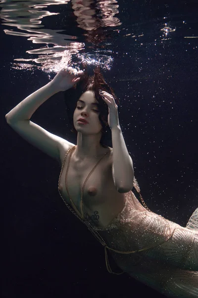 genç güzel kız üstsüz bir elbise içinde sualtı yüzer