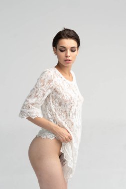 stüdyoda poz veren kız, beyaz bir gecelik ayakta