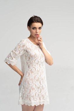 stüdyoda poz veren kız, beyaz bir gecelik ayakta