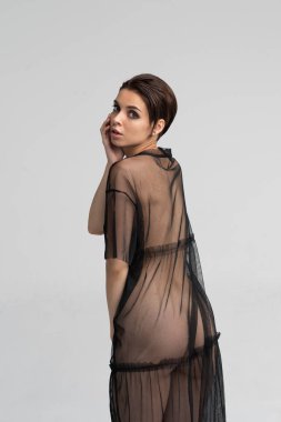 stüdyoda poz genç güzel kız, siyah şeffaf bir elbise içinde ayakta