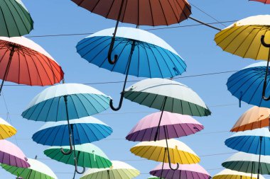 Çok renkli şemsiyeler kablolara tutunur.