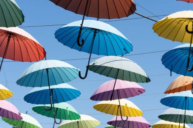 Çok renkli şemsiyeler kablolara tutunur.