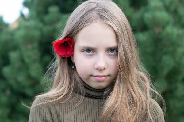 一个耳后有一朵红花的小女孩的画像 — 图库照片
