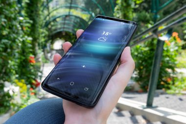 Modern smartphone bir parkta tutan kadın