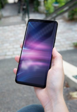 Modern smartphone bir parkta tutan kadın