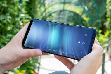 Modern smartphone bir parkta tutan kadın