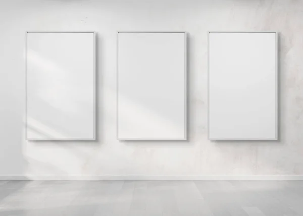 Three white frames hanging on a white wall mockup 3d rendering