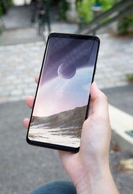 Modern smartphone bir parkta tutan kadın