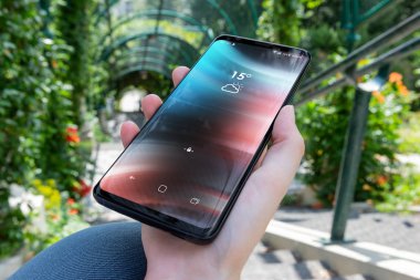 Modern smartphone bir parkta tutan kadın