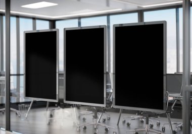 Ofis camında asılı üç siyah çerçeve. Modern şirket içi reklam panolarının taklidini yap.