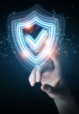 Adam, dijital kalkan koruması kullanarak koyu arkaplanda mavi holografik arayüzü 3D biçimlendiriyor