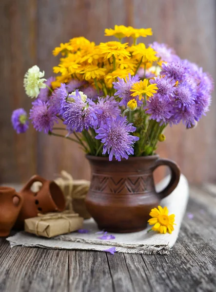 一束野花 Anthemis Tinctoria Knautia 在桌子上的陶瓷壶里 — 图库照片