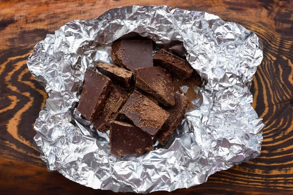 Pezzi Cioccolato Carta Stagnola Sfondo Legno Scuro — Foto Stock