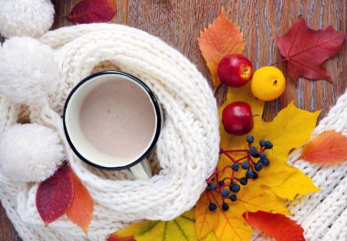 Sonbahar kompozisyon. Bir fincan kahve, renkli yaprakları ve eşarp ahşap arka plan üzerinde. Üstten görünüm.