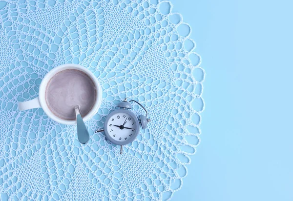早上一杯咖啡和一个浅蓝色背景的闹钟 顶部视图 文本空间 — 图库照片