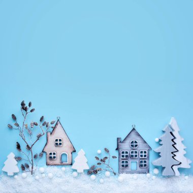 Oyuncak ile Noel kompozisyon evler, çalı çırpı ve ağaçları kar üzerinde mavi bir arka plan ile. Yeni yıl arka plan. Güzel tebrik kartı. Uzay kopyalayın. Üstten görünüm
