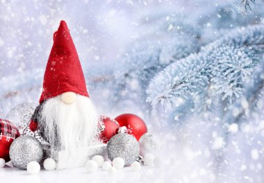 Noel gnome bir arka plan karla kaplı çam dalları üzerinde Festival süsleri ile. Noel ve yeni yıl tebrik kartı.