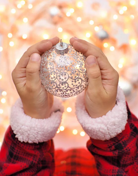 圣诞装饰球在孩子们手中的圣诞灯光的背景下 假期理念 — 图库照片