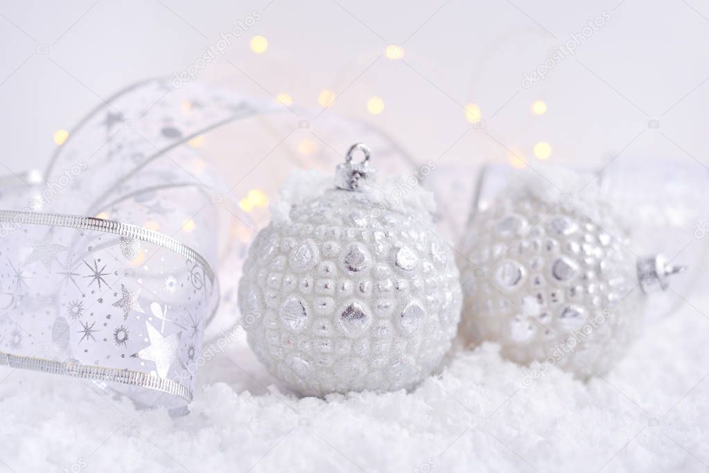 Christmas decorative balls on snow and Christmas lights. Festive Christmas background