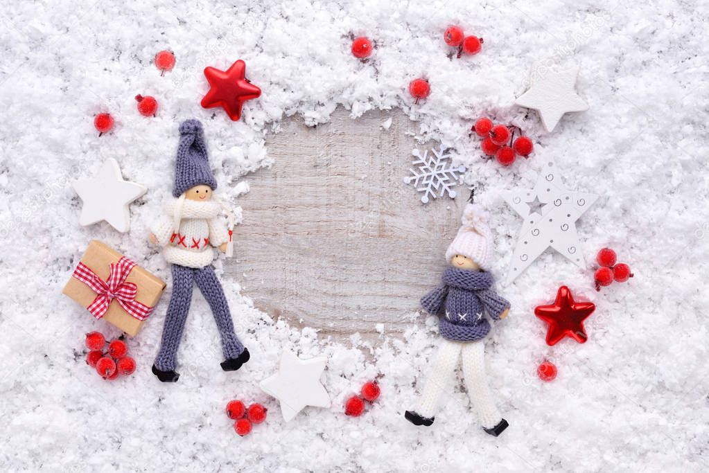 Frame of snow with toys and christmas decorations on snow-covered a wooden background. Top view, copy space. Christmas or New Year greeting card.