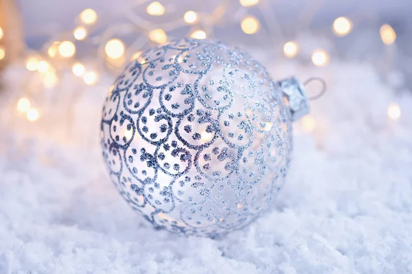 Weihnachtskugel Auf Schnee Und Weihnachtsbeleuchtung Festlicher Weihnachtlicher Hintergrund — Stockfoto