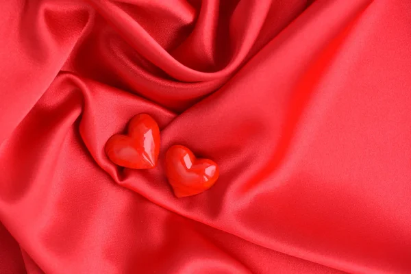 Two Glass Hearts Red Satin Fabric Background — Stock Photo, Image
