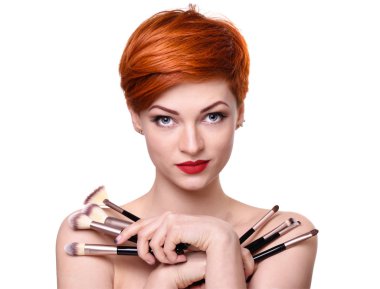 Makyaj fırçalı kısa kızıl saçlı güzel bir kadının portresi.