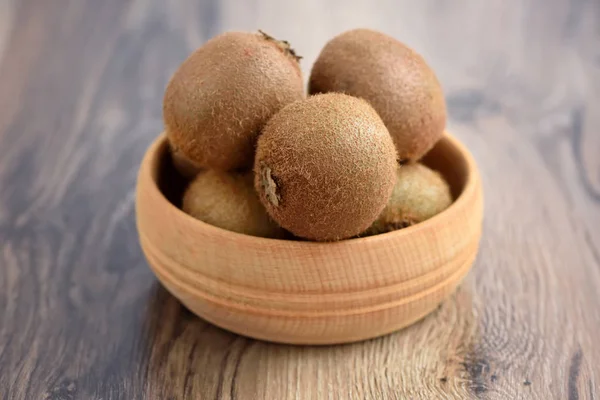 Kiwi vruchten in een kom op houten achtergrond — Stockfoto