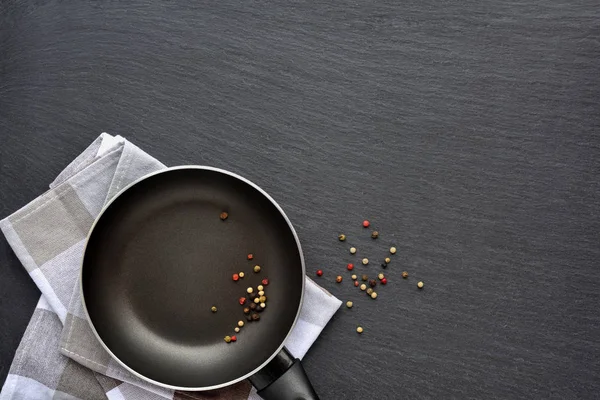 Άδειο τηγάνι με χαρτοπετσέτα και ανακατεύουμε τις πιπεριές σε σκούρο γκρι πέτρα — Φωτογραφία Αρχείου