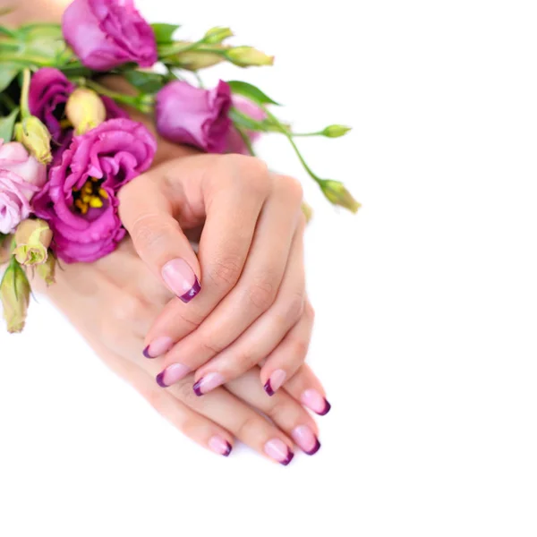 Ręce kobiety z różowy eustoma francuski manicure i kwiaty — Zdjęcie stockowe