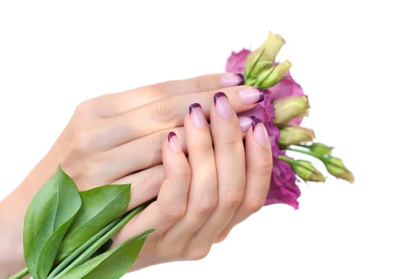 Руки жінки з рожевим французьким манікюром і еустомою квітів — стокове фото