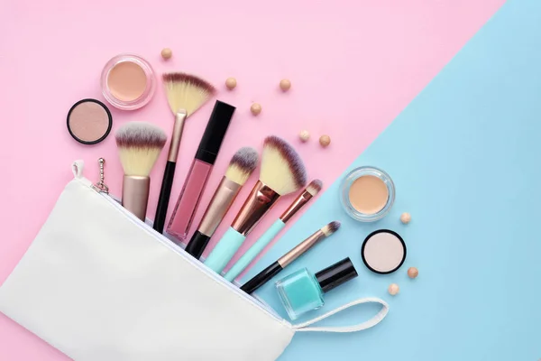Una bolsa de cosméticos blanca con productos de maquillaje que se derraman en un — Foto de Stock