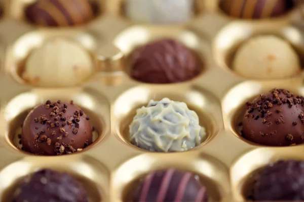 Assortiment de bonbons au chocolat dans une boîte-cadeau en or. Concentration sélective — Photo