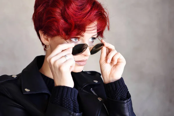 Portréja egy gyönyörű, fiatal, vörös hajú nő napszemüveget visel — Stock Fotó