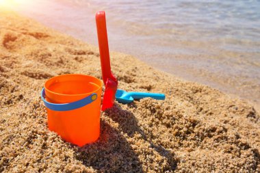 Parlak plastik çocuk plaj oyuncakları - kova ve kürek kum üzerinde denize yakın
