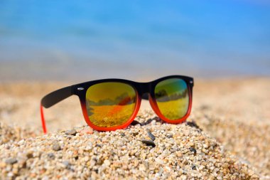 Sıcak güneşli bir günde denize yakın plajda güneş gözlüğü.