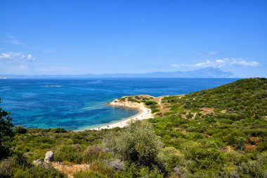 Güneşli bir günde tepelerin arasında sakin bir deniz lagünü