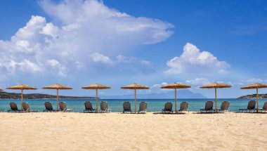 Kumsaldaki şemsiye ler ve sandalyeler. Plajdan deniz manzarası