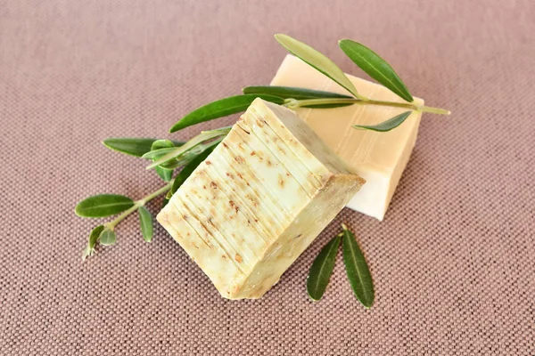 Handmade soap bars and olive branches on fabric background — Stock Photo, Image