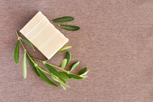 Handmade soap bars and olive branches on gunny background. — Stock Photo, Image