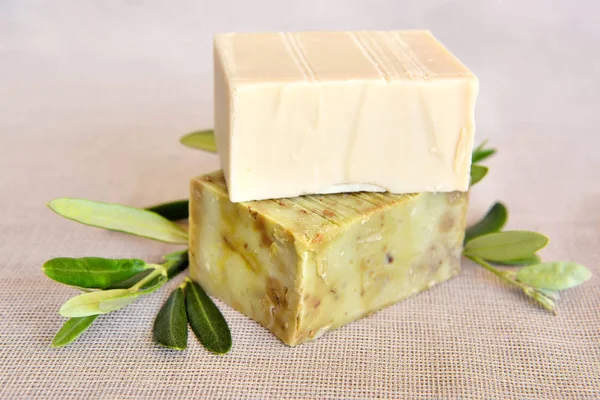 Handmade soap bars and olive branches on gunny background — Stock Photo, Image