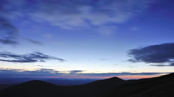 Amazing sky before sunrise in the Carpathians, silhouettes of mountains on the horizon — Stock Photo, Image