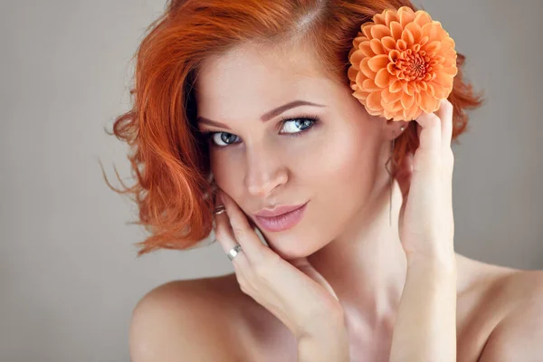 Portret Młodej Pięknej Rudowłosej Kobiety Pomarańczowym Kwiatem Patrzącej Kamerę — Zdjęcie stockowe