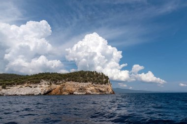 Deniz ile manzara, rock ve Blu güzel bulutlar