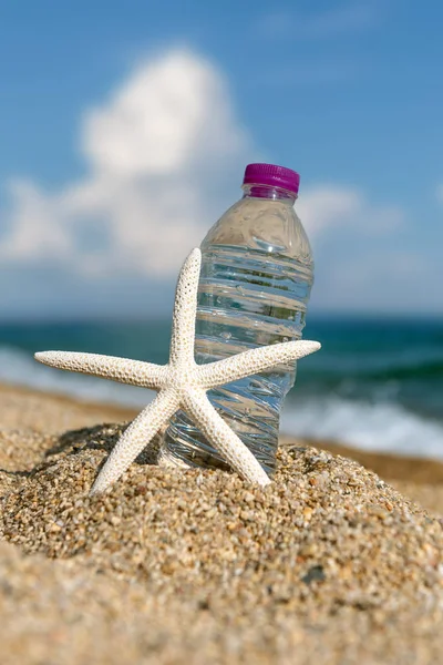 Butelka świeżej zimnej wody na piasku plażowym — Zdjęcie stockowe