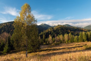 Mavili üzerinde renkli gün batımıyla inanılmaz bir dağ manzarası.
