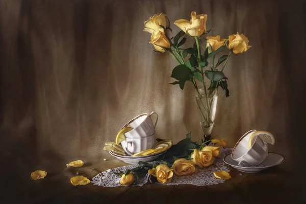 黄色いバラと白いカップの花束のある静物 ストック写真