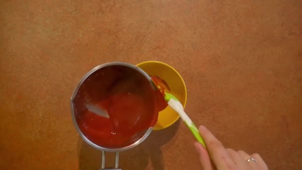 Vierta la salsa de una cacerola en un plato amarillo — Vídeo de stock