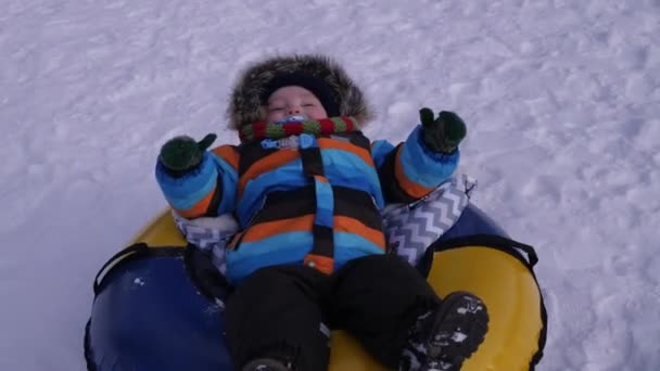 Patinaje de bebé en la nieve en el tubo — Vídeo de stock